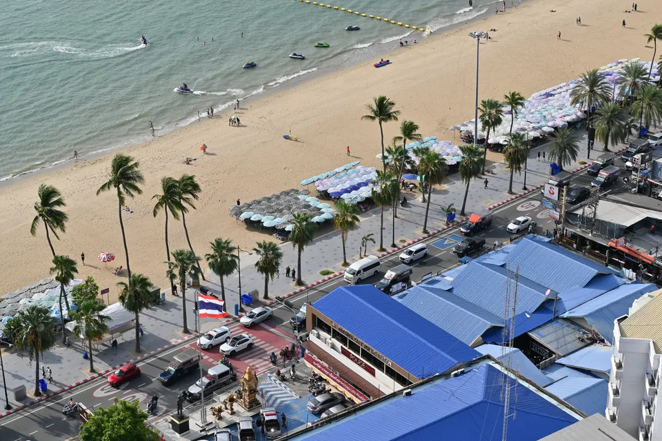 Pattaya Beach beside a palm-lined promenade and Beach Road, viewed from above.