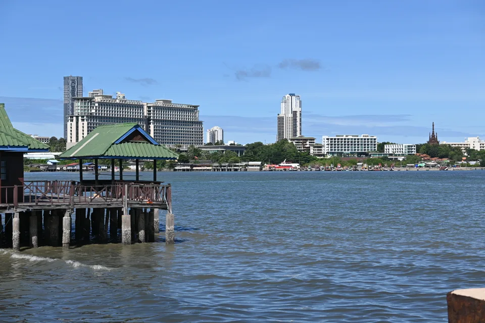 A green-roofed pavilion above the water, with the Naklua waterfront across the bay.